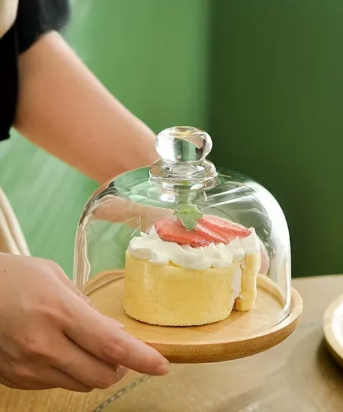 Présentoir à gâteau sous cloche en verre avec gâteau sur socle en bambou
