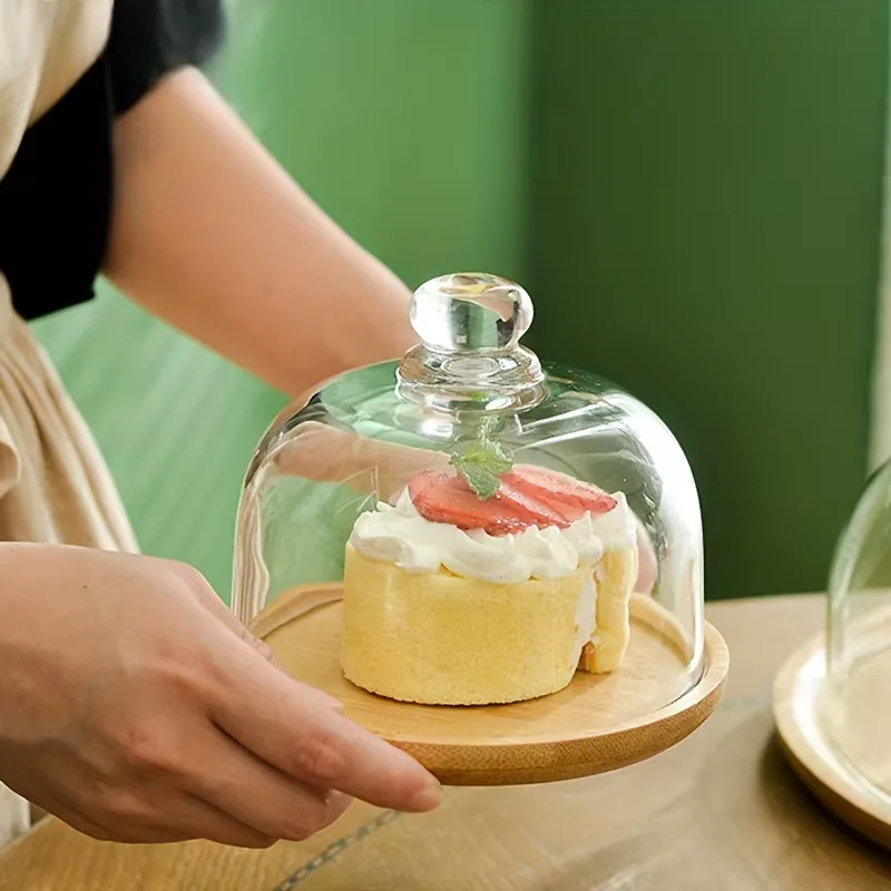 Présentoir à gâteau sous cloche en verre avec gâteau sur socle en bambou